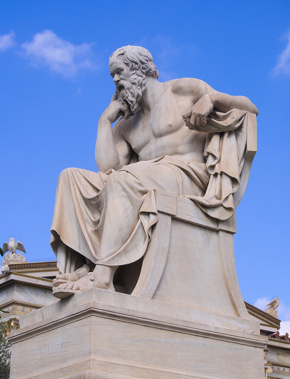 Estátua de mármore de Sócrates, na Academia de Atenas, em pose contemplativa — mão ao queixo.